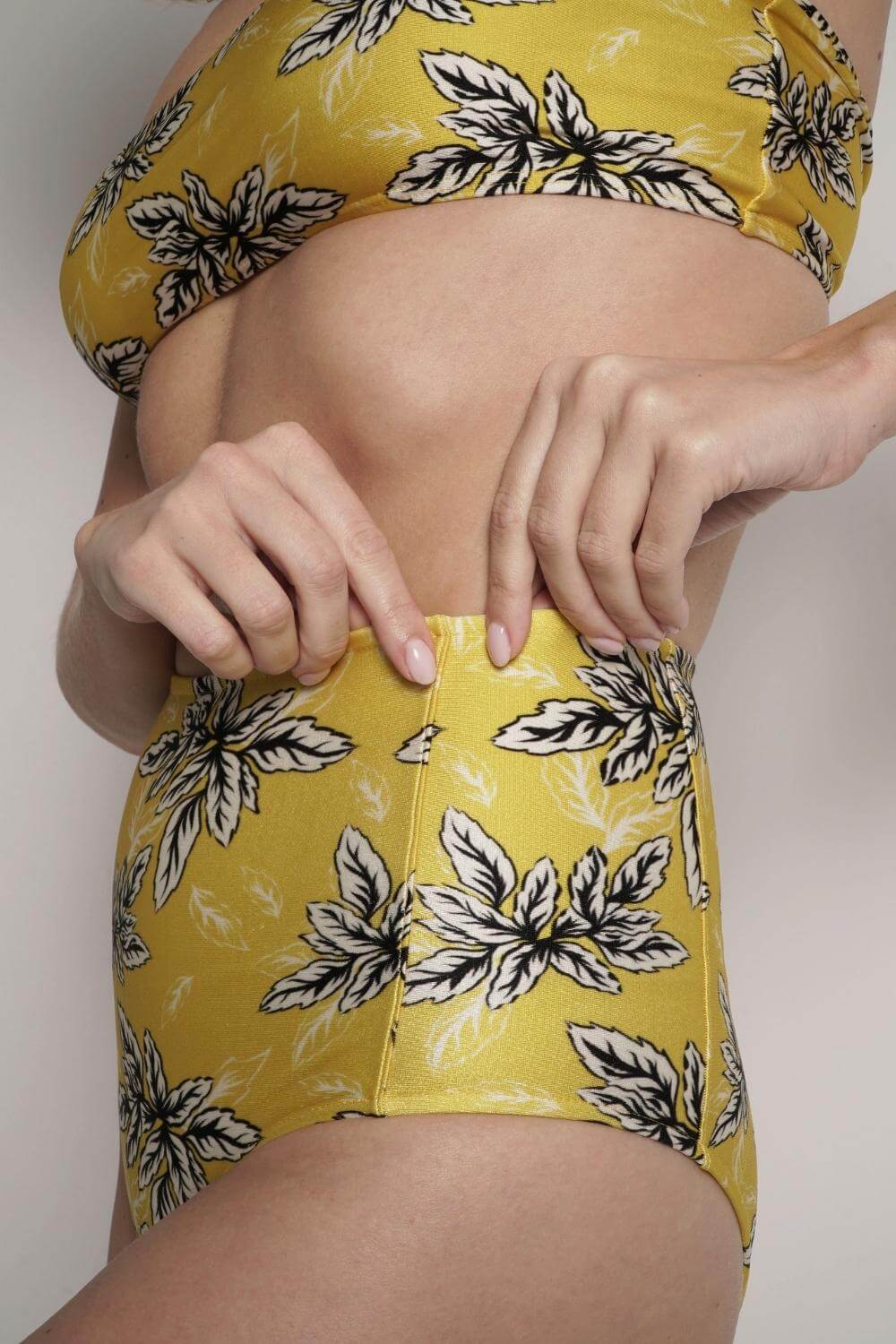 Detail of the supportive seams of the yellow print high waisted bikini bottom.