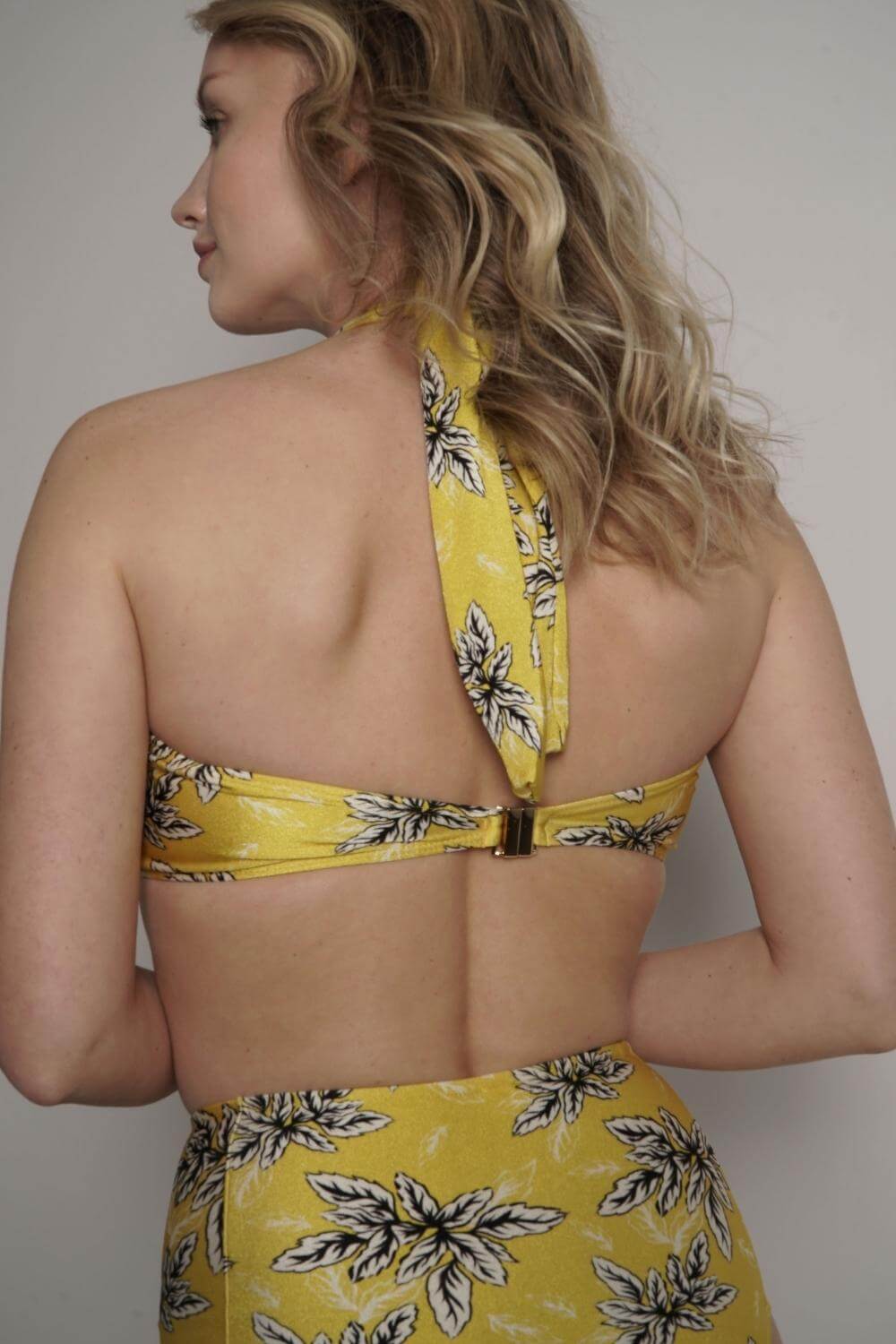 The yellow strapless bandeau bikini top closes on the back with a gold-tone clasp that is heat-free, rust-free and hypoallergenic.