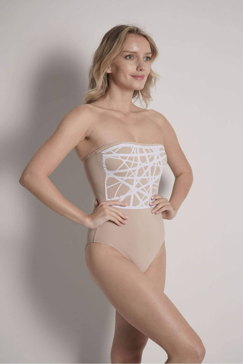 Image of the white laser-cut detail applied to the Angela strapless one piece swimsuit camel.
