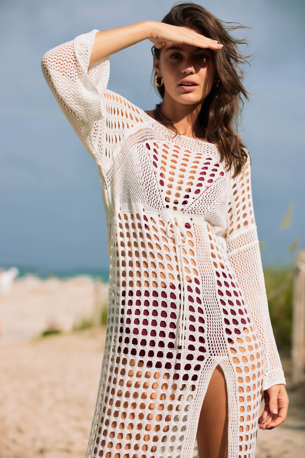 Model wears the Stella crochet cover up in white at the beach
