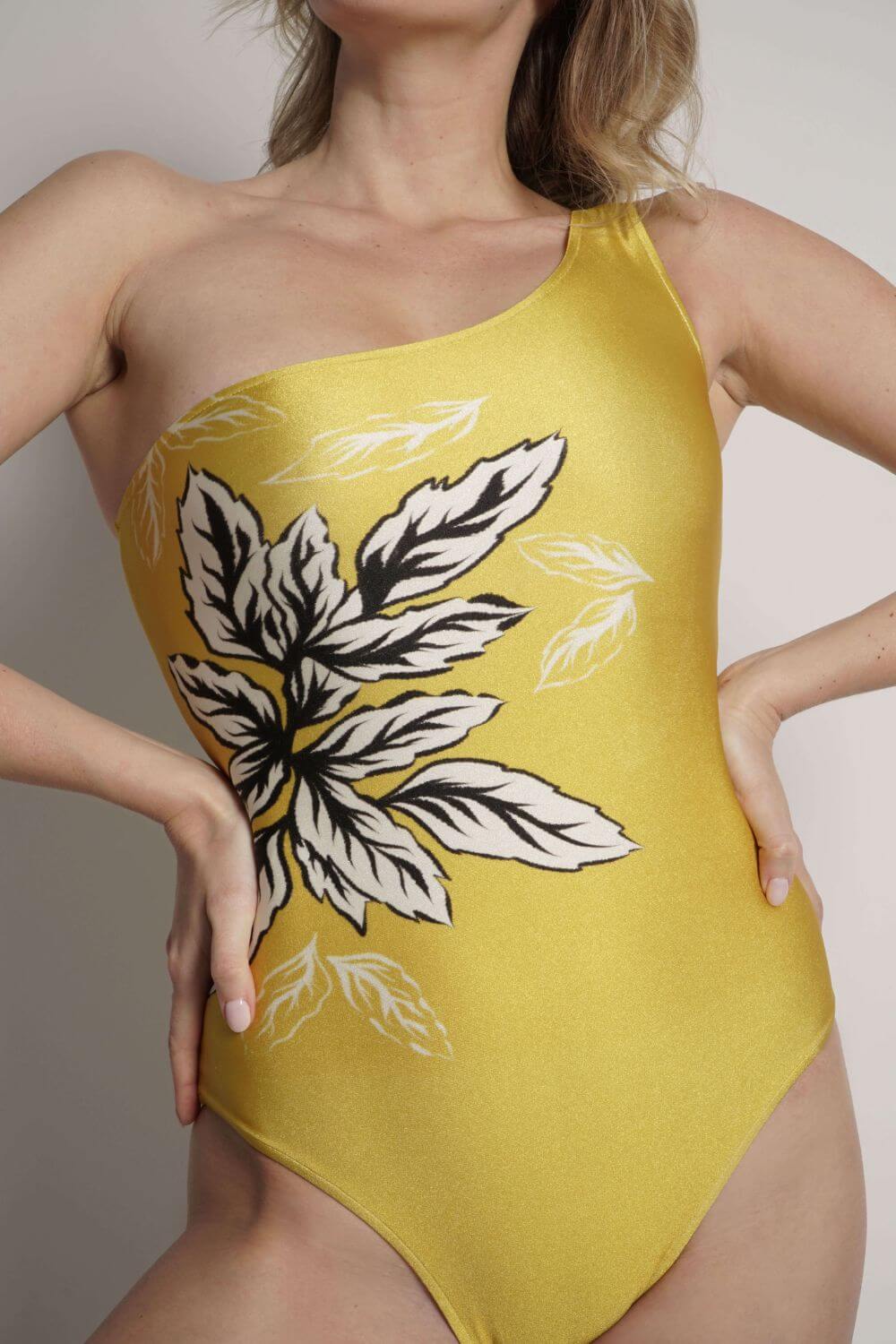 Detailed view of the exclusive print on the yellow one shoulder one piece swimsuit Becky.